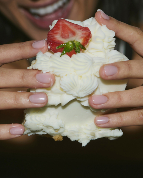 Hands with diamond rings on holding cake