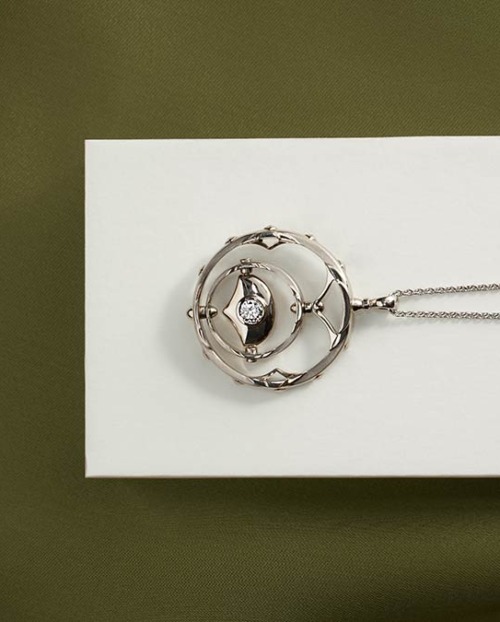 Diamond necklace on silver chain on white and green background