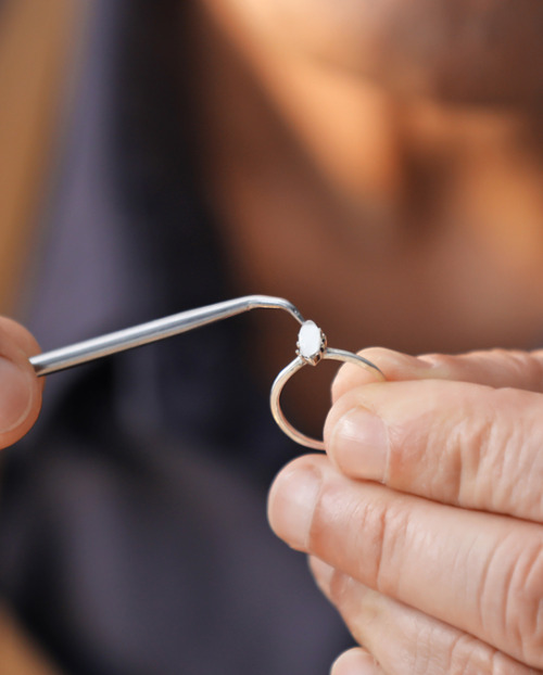 Person inspecting a cut diamond by hand
